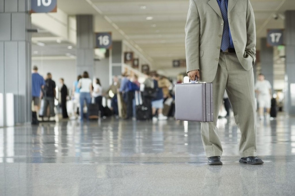 An airport concourse with many people. Airport quotes